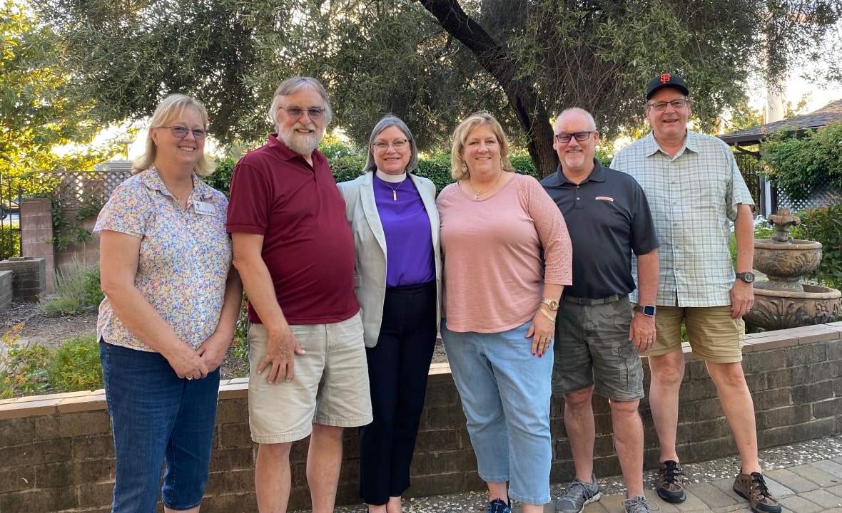 Posed group photo of vestry members standing with Bishop Lucinda